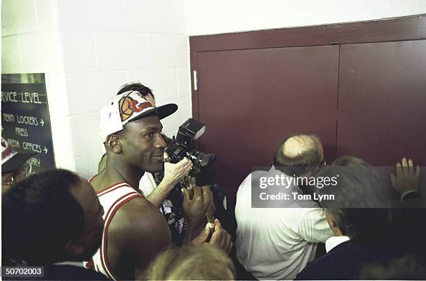 Finals Game 6. View of Chicago Bulls Michael Jordan, walking into locker room victorious, holding cigar after winning game & championship vs Seattle...