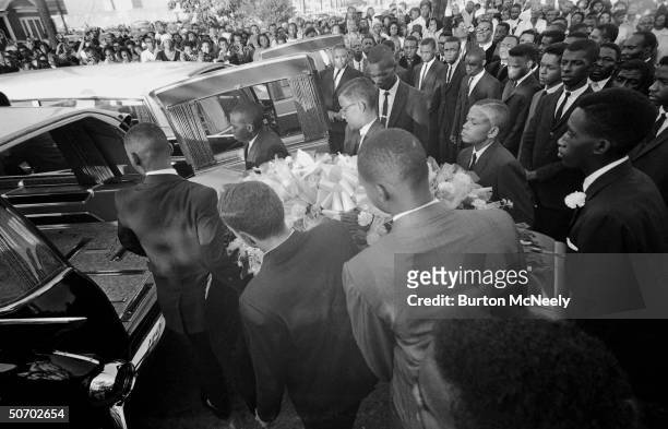 Pallbearers load a coffin into a hearse at a funeral for victims of 16th Street Baptist Church bombing, Birmingham, Alabama, late September, 1963.