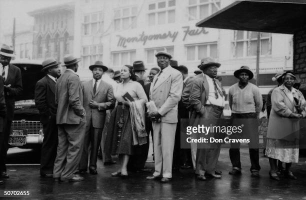 Leaders of the Montgomery bus boycott stand at a bus stop and wait for a bus following the end of the year-long protest, Montgomery, Alabama,...