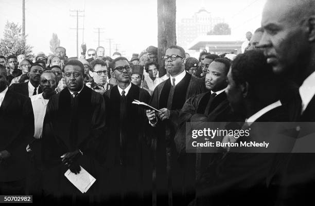 Civil rights leaders Martin Luther King , Fred Shuttlesworth, Abernathy in clerical robes after funeral for victims of church bombing.