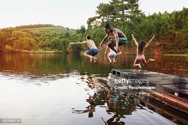 leaping free spirits - jumping into lake stock pictures, royalty-free photos & images