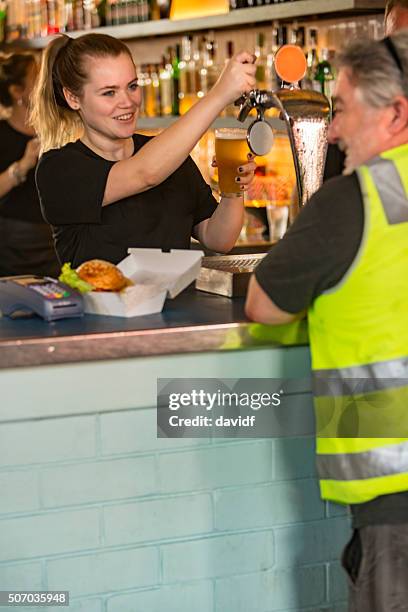 barmaid pouring beer for workman after work high visibility clothes - australian pub stock pictures, royalty-free photos & images