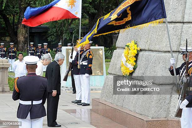 Japan's Emperor Akihito and Empress Michiko bow after laying a wreath at the monument to Philippine national hero Jose Rizal in Manila on January 27,...