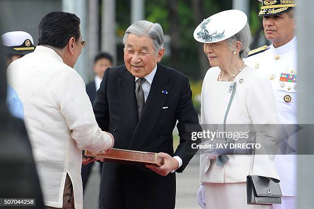 Japan's Emperor Akihito receives a symbolic key of Manila from Manila Mayor Joseph Estrada as Empress Michiko looks following a wreath laying...