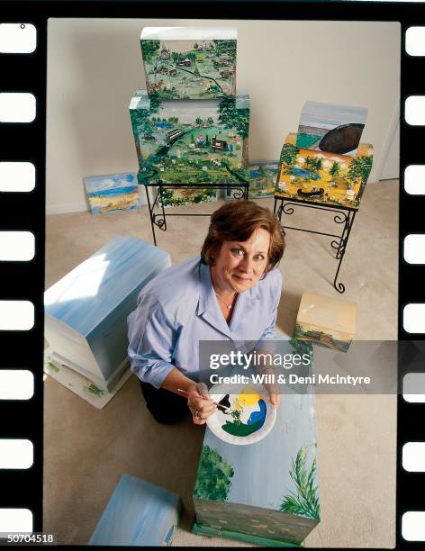 Folk artist Seton McGlennon hand-painting a pine memory trunk which tells a famiiy's life story thru interviews & family photographs.