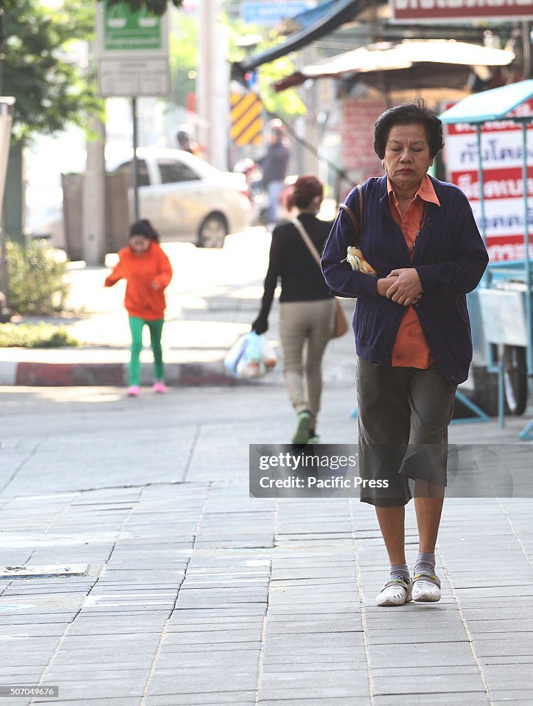 Thai woman wears long sleeves while walking in Khlong Toei...