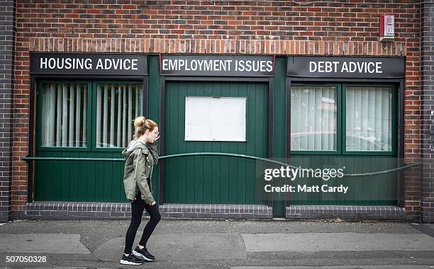 Woman walks past a advice shop on a housing estate in Bristol on August 3, 2015 in Bristol, England.
