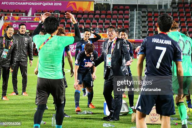 Makoto Teguramori Head coach of Japan reacts after poured water by his players to celebrate qualifying for the Rio de Janeiro Olympics after winning...