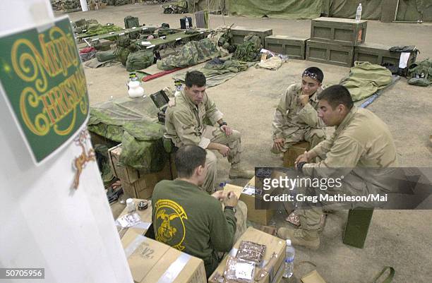 Marines from the 15th Marine Expeditionary Unit security detachment passing time during their off hours playing cards in a warehouse next to the...