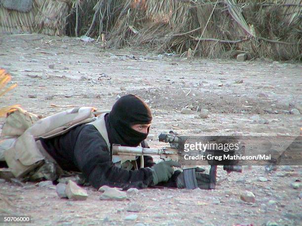 Navy Seal member providing cover for his teammates advancing on a suspected location of al-Qaeda and Taliban forces. Navy special operations forces...