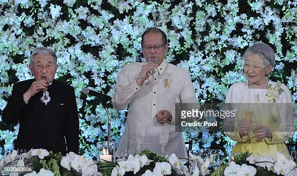 Visiting Japanese Emperor Akihito and Philippine President Benigno Aquino offer a toast as Empress Michiko looks on during a state dinner at the...