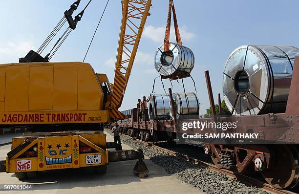 Indian workers unload freight from an Indian Railways train at a new private freight terminal in Sachana village near Viramgam, some 50 kms from...