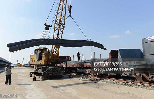 Indian workers unload freight from an Indian Railways train at a new private freight terminal in Sachana village near Viramgam, some 50 kms from...