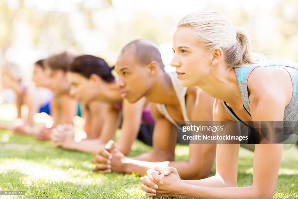 Woman With Friends In Plank Position In Bootcamp