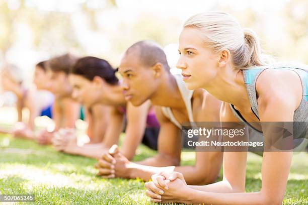 woman with friends in plank position in bootcamp - boot camp stock pictures, royalty-free photos & images