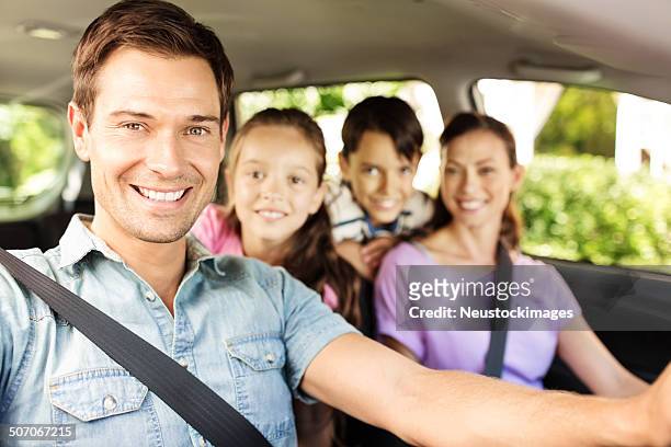 feliz hombre sentado con su familia en coche - four people in car fotografías e imágenes de stock