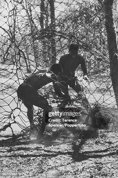 Native scouts catching a bushback antelope during animal rescue operation from the Kariba dam.