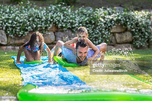 family having fun in the garden - two kids playing with hose stock pictures, royalty-free photos & images