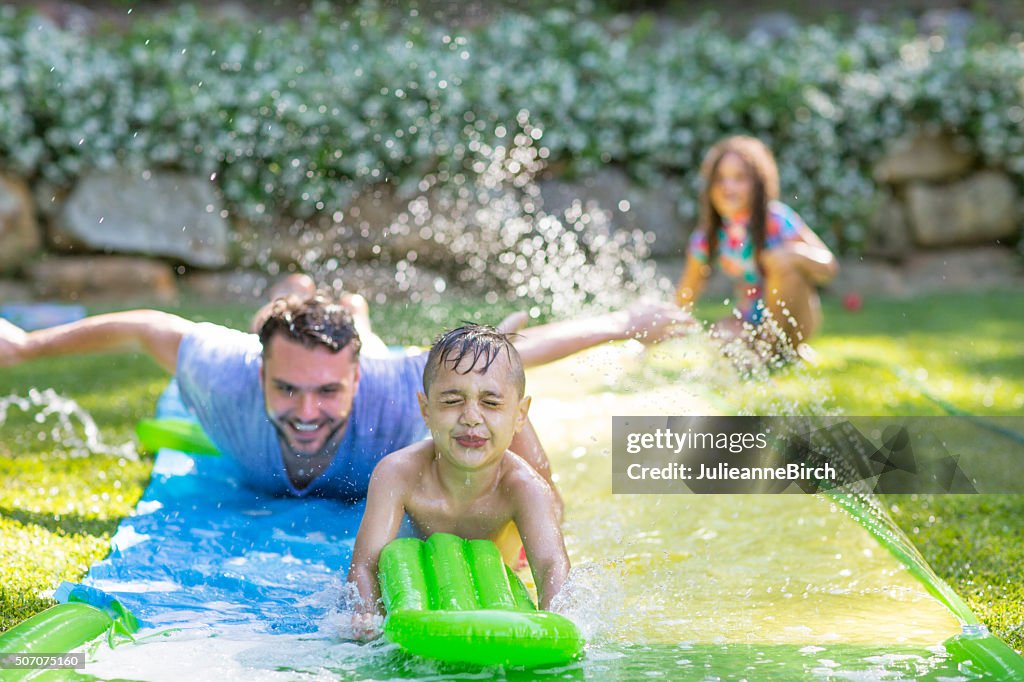 Family in garden playing water games