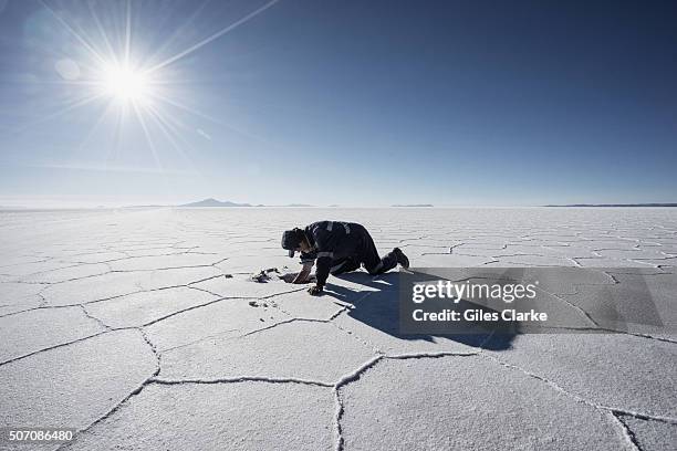 Man who goes by the name Theo digs for salt crystals in the Salar de Uyuni, a flat salt plain that covers just over 4,000 square miles and lies at...