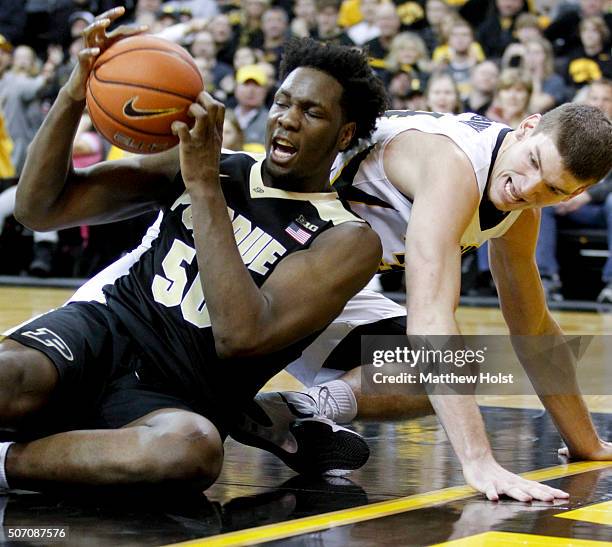 Center Adam Woodbury of the Iowa Hawkeyes battles for a loose ball with forward Caleb Swanigan of the Purdue Boilermakers, in the first half on...