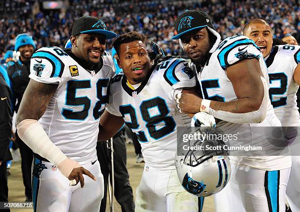 Thomas Davis, Jonathan Stewart, and Charles Johnson of the Carolina Panthers pose for a photograph during the NFC Championship Game against the...