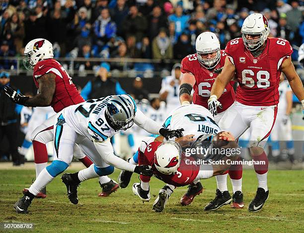 Mario Addison and Kawann Short of the Carolina Panthers force a fumble by Carson Palmer of the Arizona Cardinals during the NFC Championship Game at...