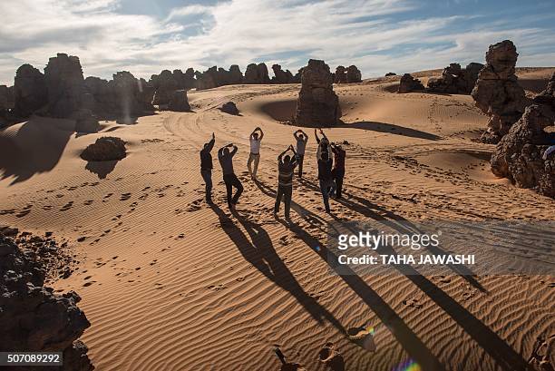 Tourists practice yoga in the Meggedat valley, north west of Libya's Akakus mountain region, in the desert of the western Ghat District, on January...