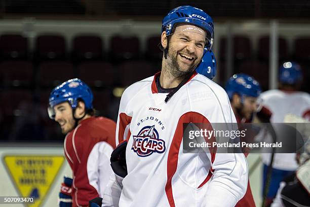 John Scott, a 6-foot-8 brawler type hockey player, shares a laugh with his teammates as he practices with the St. John's Ice Caps, an AHL affiliate...