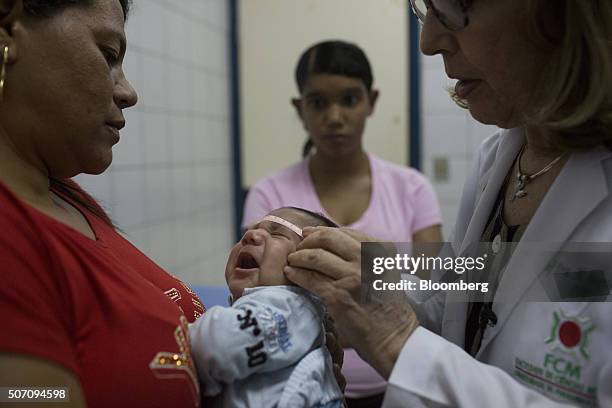 Doctor Angela Rocha, right, measures the head of one-month-old baby Alexandro Julio while his grandmother, left, and mother Julie Adriana look on at...