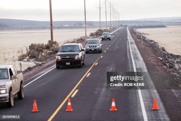 Vehicles exit a closed Highway 78 located approximately 4 miles from the Malheur Wildlife Refuge Headquarters near Burns, Oregon on January 27, 2016....