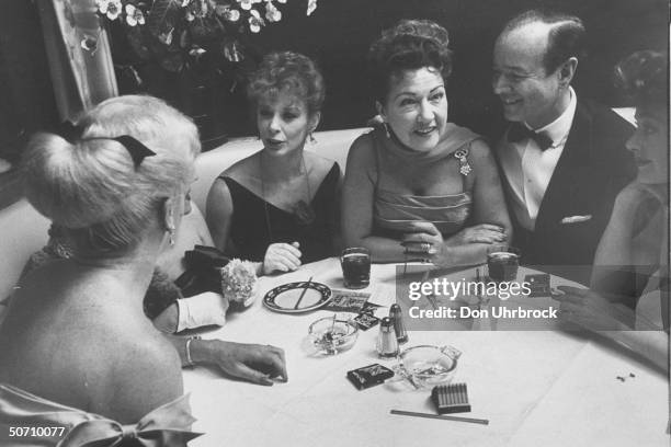 Actresses Gwen Verdon & Ethel Merman sitting at a dinner party.