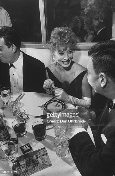 Actress Gwen Verdon sitting at a dinner party.