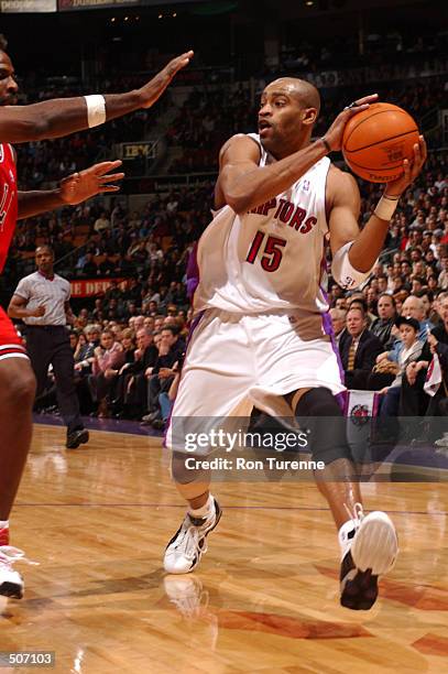 Vince Carter of the Toronto Raptors looks for the open man as former teammate Charles Oakley of the Chicago Bulls defends at Air Canada Centre in...