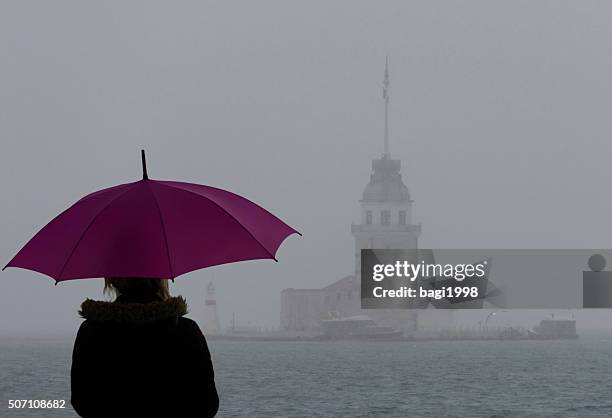 mujer observando a kiz kulesi - lluvia fotografías e imágenes de stock