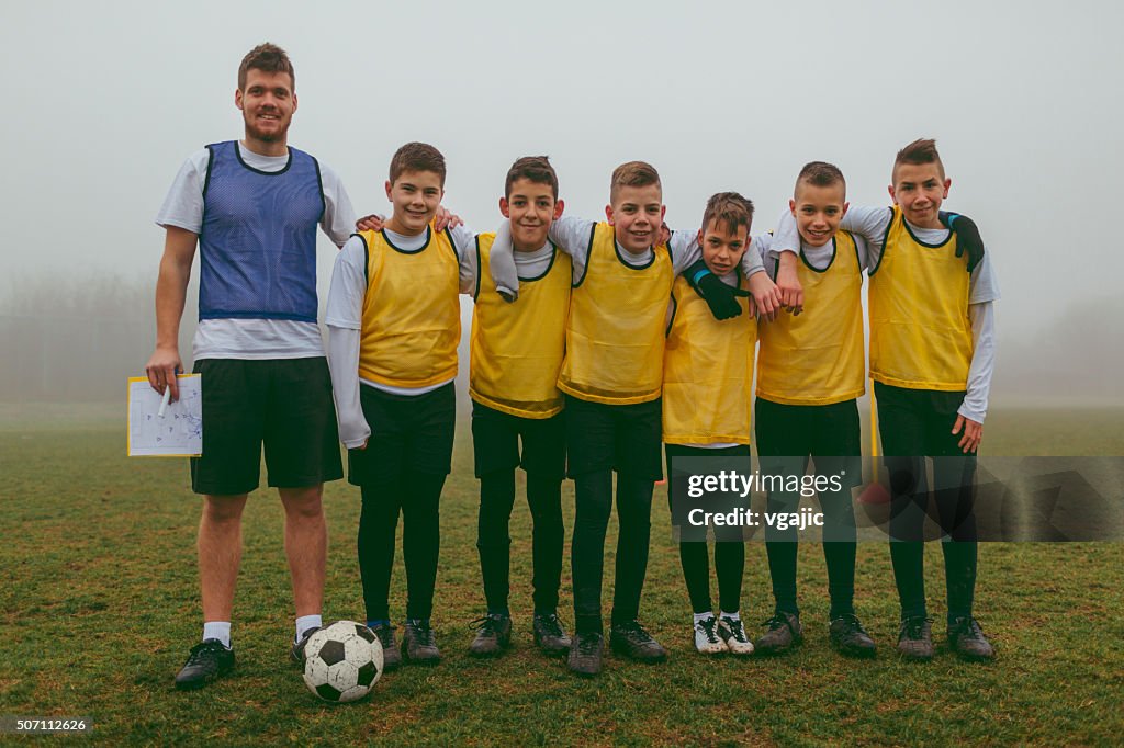 Portrait of Kids Team With Coach After Playing soccer