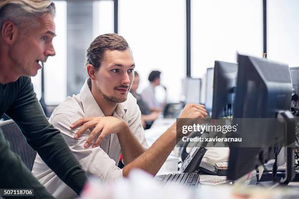 businessmen reviewing some financial work - computer help stock pictures, royalty-free photos & images