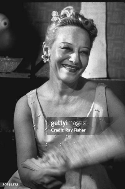 Famed nude fan dancer Sally Rand in her dressing room, holding a fan.