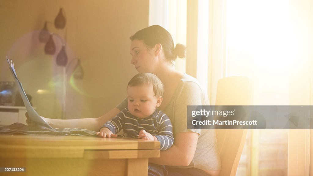 Mother sat with child worrying about her finances