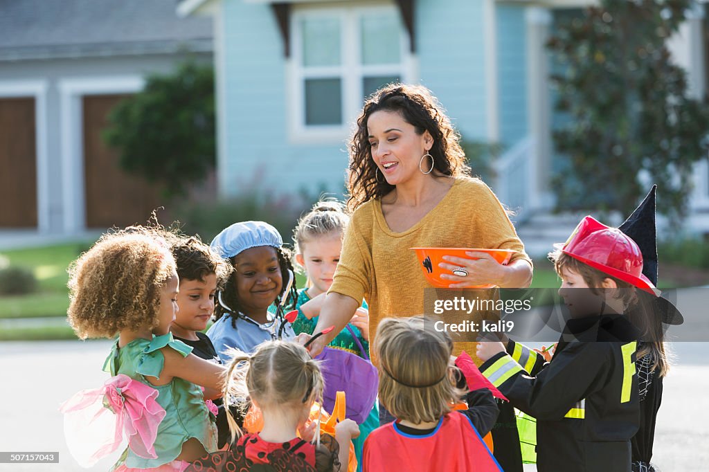 Woman giving candy to children trick or treating