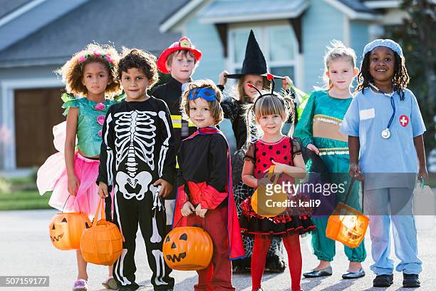 group of children in halloween costumes standing outdoors - stage costume stock pictures, royalty-free photos & images