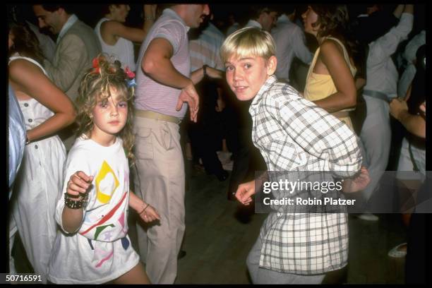 Actor Ricky Schroder and Drew Barrymore dancing.