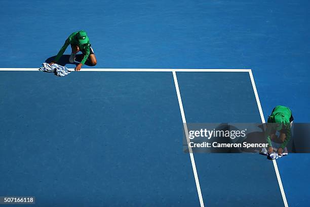 Ball kids dry the lines on the court during a break in play in the semi final match between Johanna Konta of Great Britain and Angelique Kerber of...