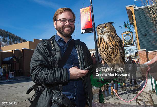 Getty Images photographer Rick Kern poses for a photo with Bubo the Eagle Owl of Earthwings.org during the Sundance Film Festival on January 27, 2016...