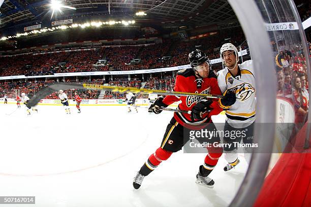 David Jones of the Calgary Flames checks a player on the Nashville Predators during an NHL game at Scotiabank Saddledome on January 27, 2016 in...