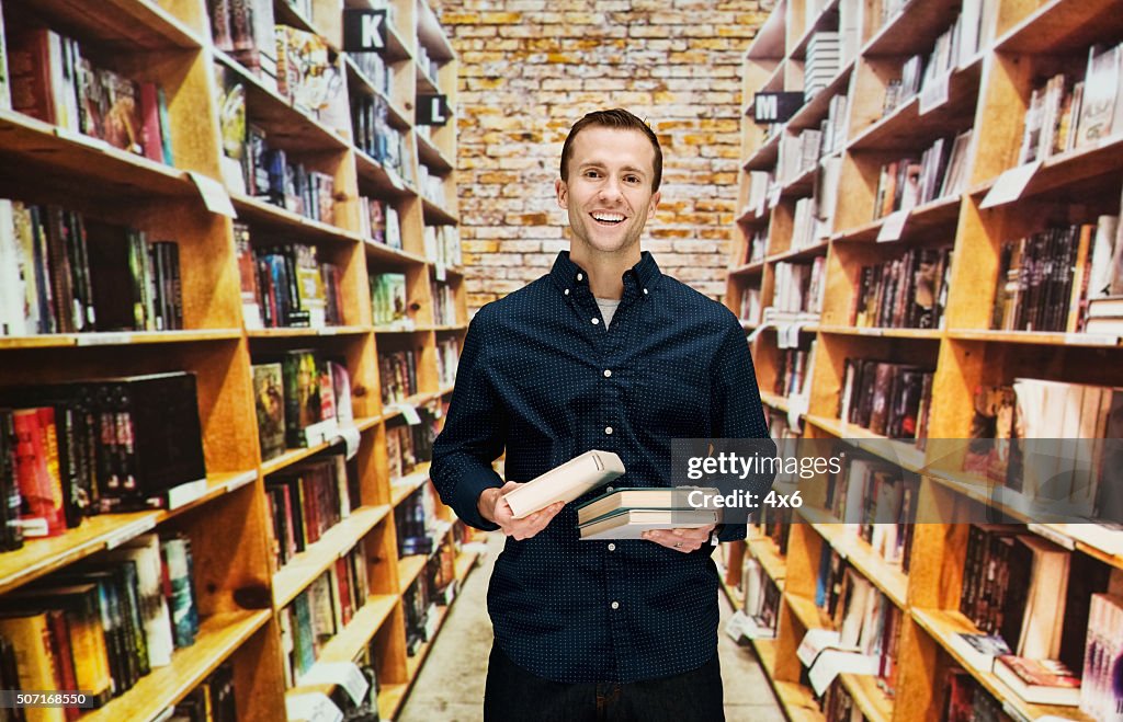 Smiling male bookseller in library