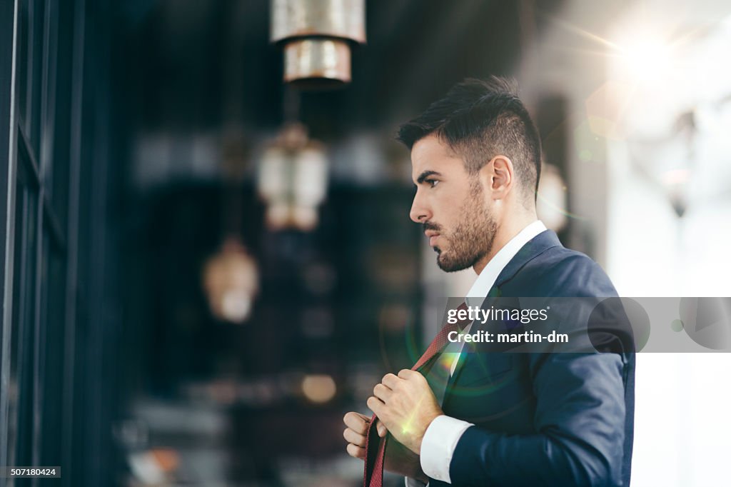 Businessman getting dressed in front of the mirror