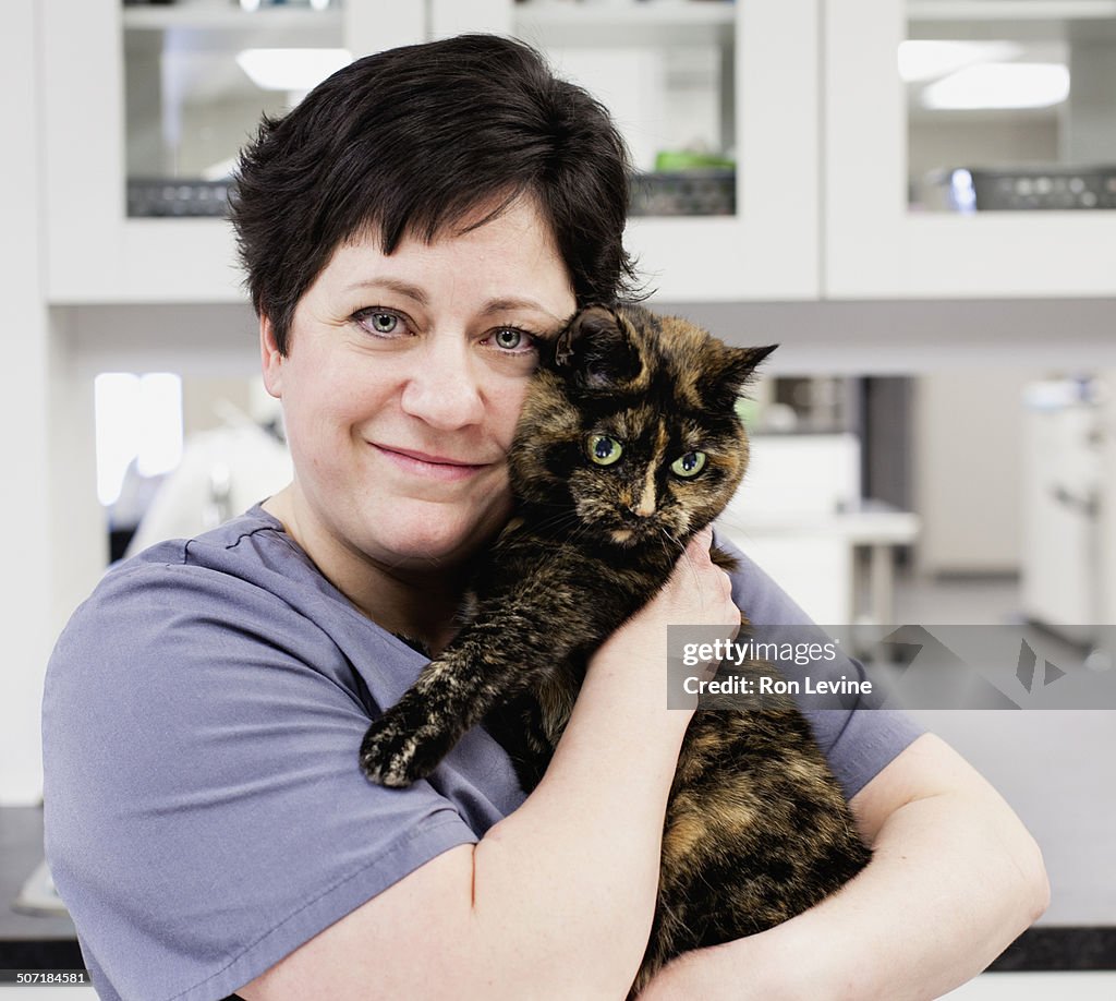 Veterinarian hugging her feline patient