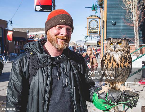 Getty Images photographer Mat Hayward poses for a photo with Bubo the Eagle Owl of Earthwings.org during the Sundance Film Festival on January 27,...