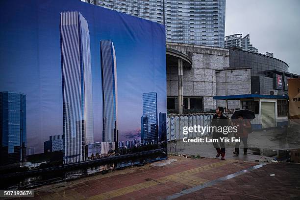 People walk on a street at Houjie town on January 27, 2016 in Dongguan, China. China's slowing economy and falling stock market have caused concerns...